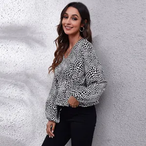Detail view of a stylish V-neck chiffon blouse featuring a black heart print and lantern sleeves.