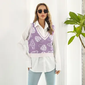 Primer plano de un chaleco de punto morado con motivo de setas sobre una camisa blanca