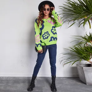 Full lifestyle shot of lime green floral knit sweater with black hat and boots.