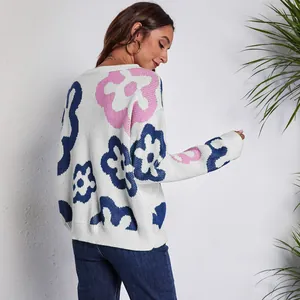 Detail view of women's loose knit sweater featuring pink and blue floral jacquard pattern