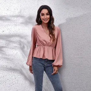 Modische rosa Chiffonbluse mit V-Ausschnitt, Laternenaermeln und tailliertem Schnitt.
