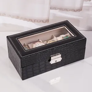 Dettaglio di una scatola porta orologi in pelle nera con motivo a coccodrillo e chiusura.