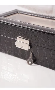 Dettaglio della serratura e chiave in argento su scatola porta orologi in pelle nera cocco