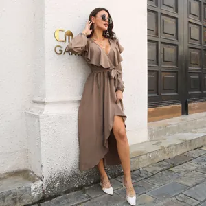 Elegant brown wrap maxi dress with ruffles and V-neckline shown in an outdoor setting.