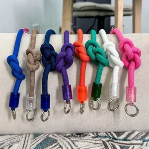 Detalle de varias correas de bolso de nailon trenzado multicolor con anillas de metal