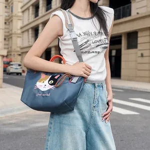 Nahaufnahme einer blauen Handtasche im japanischen Stil mit süßer Katzenstickerei
