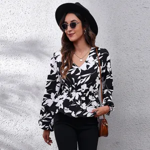 Elegant black and white floral print blouse with V-neck and lantern sleeves on model