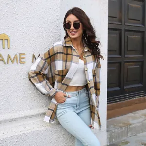 Full-length view of a woman wearing a plaid shirt jacket with light blue denim jeans.