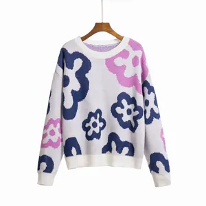 Close-up of white floral jacquard knit sweater with drop shoulders and round neck
