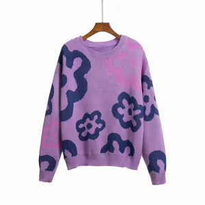 Close-up detail of a purple knitted sweater with vibrant large flower jacquard patterns