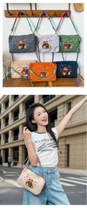 Vue de style rue d'un sac à bandoulière japonais brodé d'un ours avec sangle colorée