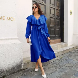 Outdoor street style shot of a woman in a royal blue ruffled V-neck maxi dress