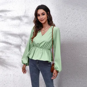 Modell trägt eine hellgrüne Chiffonbluse mit V-Ausschnitt und Laternenärmeln