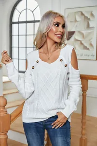 Detailed shot of white cable knit sweater with buttons and cold-shoulder design