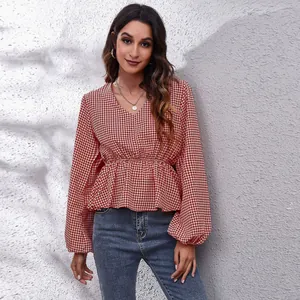 Detail of a chic red houndstooth peplum blouse with a V-neck and elegant lantern sleeves