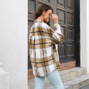 Side view of woman wearing a long-sleeved yellow and white plaid wool-mix shirt jacket