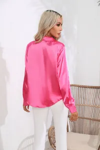 Elegante Rückansicht einer leuchtend rosa Satinbluse mit Langarm und schickem Reverskragen.