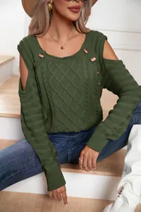 Detail view of the green cable-knit sweater featuring cold-shoulder and button accents.
