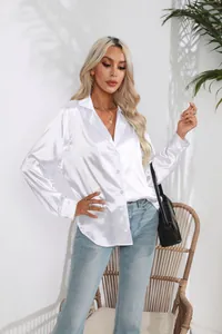 Detailansicht einer weißen Satin-Langarmbluse mit elegantem Reverskragen und Knöpfen.