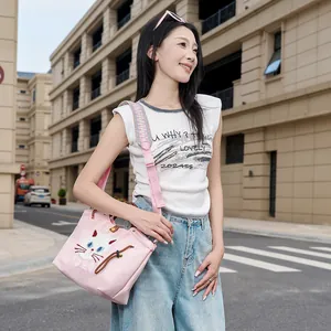 Japanische rosa Canvas-Tasche mit süßer Katzenstickerei, von einem Model getragen