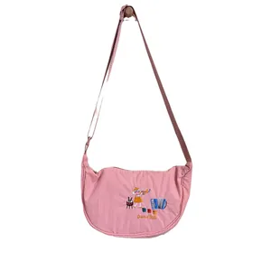Pink embroidered crescent dumpling bag with cartoon character design and strap