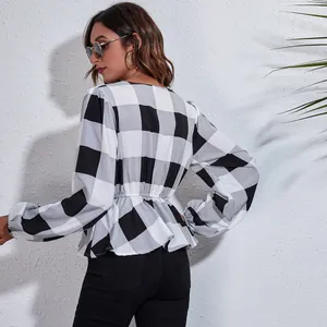 Elegant V-neck checkered blouse with cinched waist and lantern sleeves.