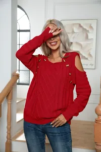Detailed shot of red cable knit sweater featuring cold shoulder and button accents.
