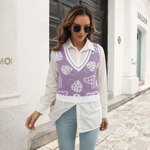 Detail view of a purple mushroom jacquard knit vest styled over a white long-sleeve shirt.