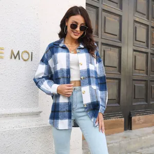 Stylish woman wearing a blue and white plaid shirt jacket with light jeans outdoors.