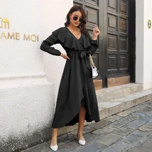 Full view of elegant black wrap dress featuring ruffle neckline and high-low slit