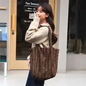 Asian model carrying a large capacity striped wool tote bag in a trendy autumn lifestyle scene