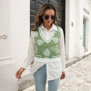 Detailed shot of women's green mushroom jacquard knit vest in casual street style outfit.