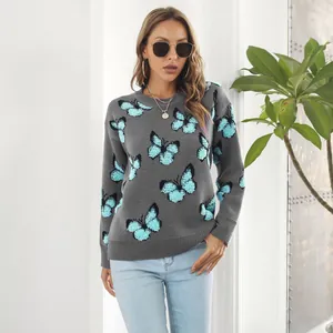 Vista detallada del patrón de jacquard de mariposa azul en un suéter de punto Y2K gris.
