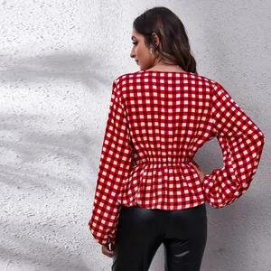 Back view of a red and white gingham blouse with lantern sleeves and peplum waist