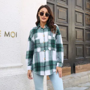 Outdoor lifestyle shot of a woman wearing a green and white plaid flannel shirt jacket