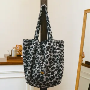 Close-up detail of leopard print fuzzy wool tote bag with a golden handmade tag
