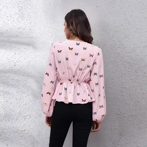 Back view detail of pink butterfly print chiffon blouse with cinched waist and lantern sleeves.