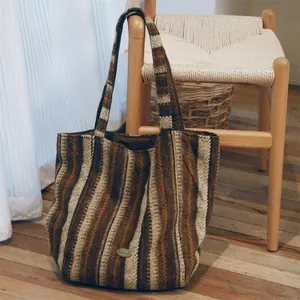 Detailed view of a large striped wool tote bag placed next to a wooden chair