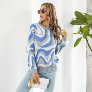 Female model wearing a blue and grey tie-dye jacquard sweater in a bright indoor setting