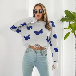 Detail view of white Y2K cropped sweater with blue butterfly jacquard and ripped hem