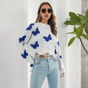 Y2K distressed knit sweater with blue butterfly jacquard pattern and ripped hem detail.
