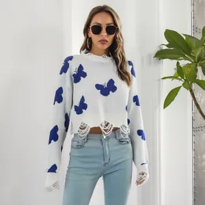Detailed view of white Y2K distressed cropped sweater featuring blue butterfly patterns and rips