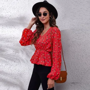 Detail view of red floral V-neck chiffon blouse with lantern sleeves and cinched waist