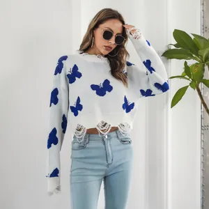 Detail of Y2K style white cropped sweater with blue butterfly jacquard and distressed edges