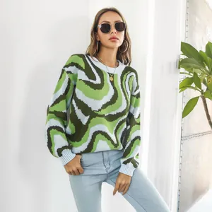 Detail view of women's loose long sleeve knit sweater with green wavy jacquard pattern.