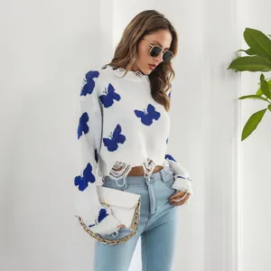 Stylish model in Y2K distressed white sweater featuring blue butterfly jacquard patterns