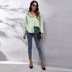 Ganzkörperansicht einer Frau in einer mintgrünen langärmeligen Satinbluse im Streetstyle.