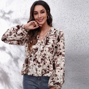 Detail view of a V-neck chiffon blouse with lantern sleeves and abstract print.