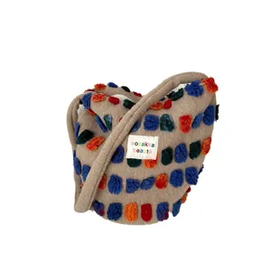 Modische Plüsch-Eimertasche mit bunten Pompons und einem sehr weichen Schultergurt