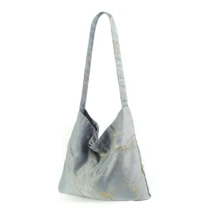 Vista dettagliata di una borsa tote azzurra con eleganti motivi marmorizzati oro